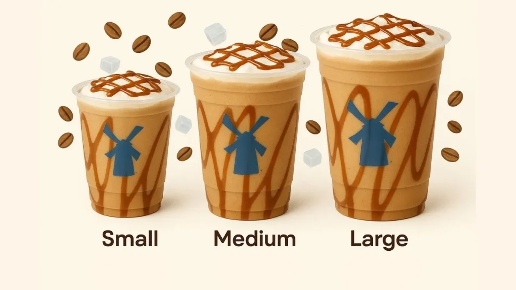 Three clear plastic cups of Dutch Bros Freeze blended coffee, shown in Small, Medium, and Large sizes. They are light brown, topped with white foam and a caramel drizzle lattice design. Each cup features the blue Dutch Bros windmill logo. Coffee beans and white sugar cubes float around the drinks.